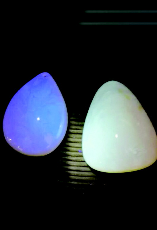 左边蜜蜡是假货,右边蜜蜡是真品,在紫光灯下荧光反应不同.